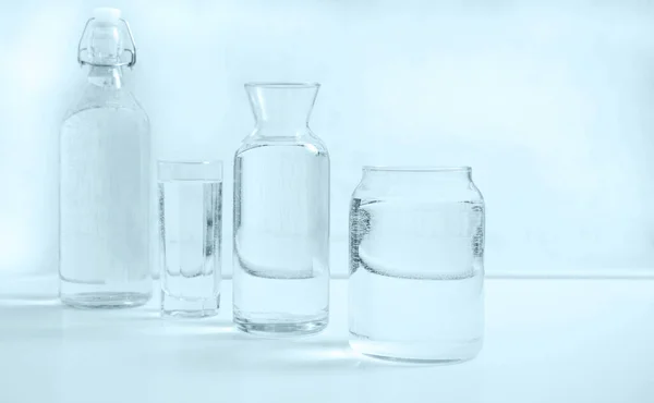 瓶に白いテーブルの上に透明なガラスが付いた水のボトル キッチンのインテリア 純飲料水 透明アクア — ストック写真