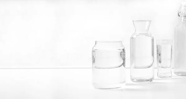 Βάζο Μπουκάλι Νερό Πλήρη Διαφανή Ποτήρια Λευκό Τραπέζι Εσωτερικό Κουζίνας — Φωτογραφία Αρχείου