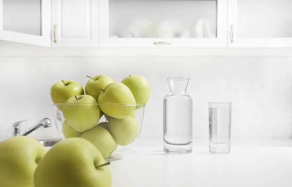 Čerstvě Umytá Jablka Kuchyňském Stole Láhev Plnou Sklenici Vody Pozadí — Stock fotografie