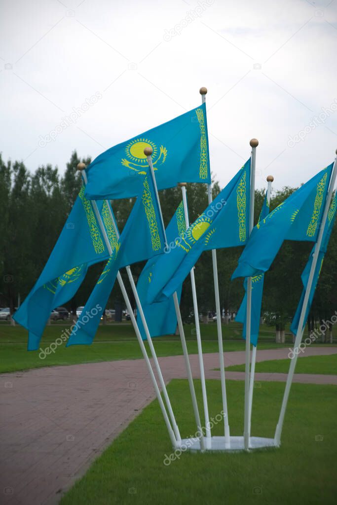 many Kazakhstan national flags on background of summer park in Nur-Sultan  - Astana. capital city of  Republic of Kazakhstan
