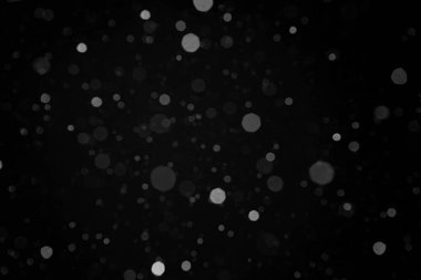 Düşen gerçek orta büyüklükteki kar tanelerinin fotoğrafı harmanlama modu için siyah arkaplan üzerine odaklı değil. Gece sahnesi. Yeni yıl ve mutlu noeller dekorasyon fikri.