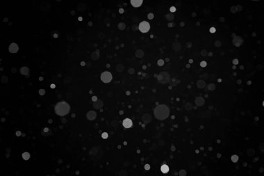 Düşen gerçek orta büyüklükteki kar tanelerinin fotoğrafı harmanlama modu için siyah arkaplan üzerine odaklı değil. Gece sahnesi. Yeni yıl ve mutlu noeller dekorasyon fikri.