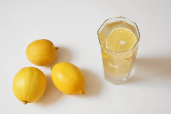 Saf Içme Suyu Beyaz Masada Şeffaf Bir Bardakta Limon Yan — Stok fotoğraf