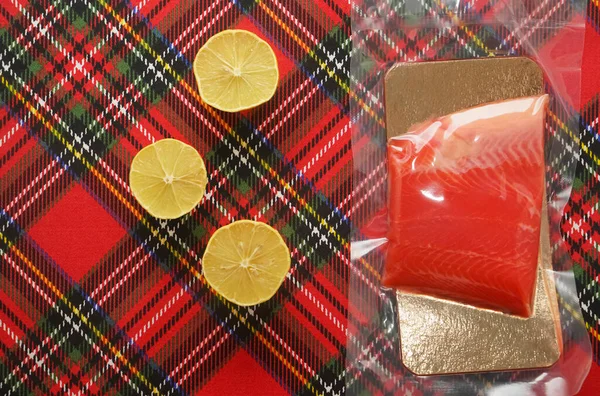 생연어 스테이크에 레몬을 곁들인 위에요 줄무늬 식탁보 — 스톡 사진