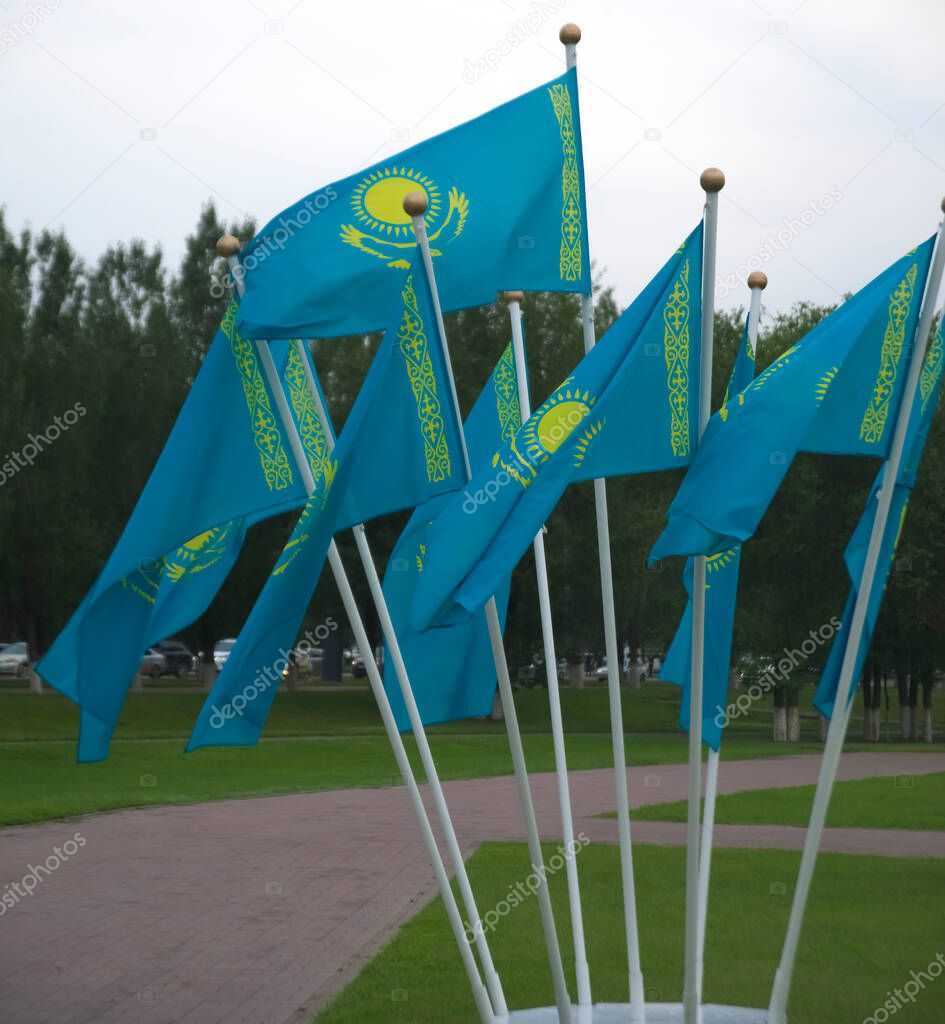many Kazakhstan national flags on background of summer park in Nur-Sultan  - Astana. capital city of  Republic of Kazakhstan