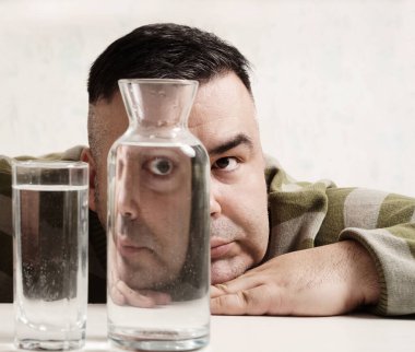 surreal portrait of a strange man looking through glasses of water. man looking through glass glasses of water with reflections and distortions. isolated on white background.