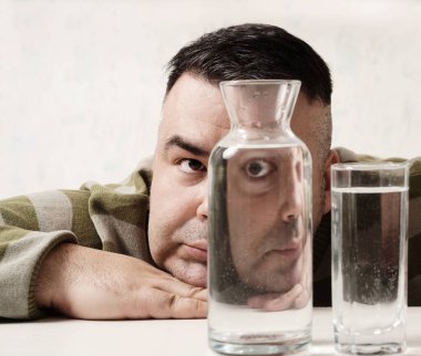 surreal portrait of a strange man looking through glasses of water. man looking through glass glasses of water with reflections and distortions. isolated on white background.