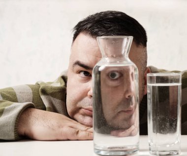 surreal portrait of a strange man looking through glasses of water. man looking through glass glasses of water with reflections and distortions. isolated on white background.