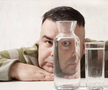 surreal portrait of a strange man looking through glasses of water. man looking through glass glasses of water with reflections and distortions. isolated on white background.