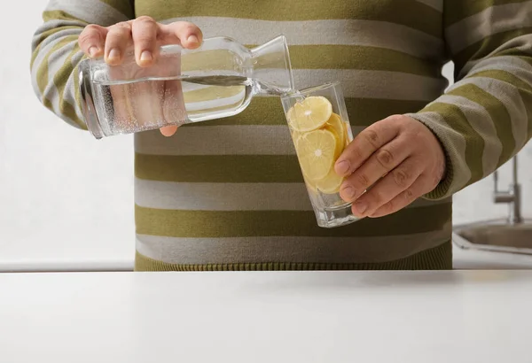 Man Pouring Water Bottle Transparent Glass Background Kitchen Interior Face — Zdjęcie stockowe