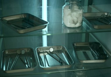 Mavi arka planda diş aletleri. Diş tedavisi ve diş hijyeni. Dişçi aletleri, ayna, kanca, spatula. UV tedavi dolabı