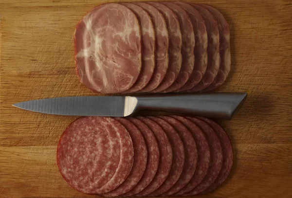 Aufgeschnittene Salami Eisernes Messer Und Schneidebrett Isoliert Auf Schwarzem Holztischhintergrund — Stockfoto