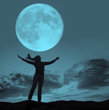 Dalgaya ve dolunaya bakan ellerini kaldırmış bir kadının silüeti..