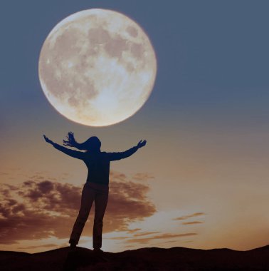 Dalgaya ve dolunaya bakan ellerini kaldırmış bir kadının silüeti..