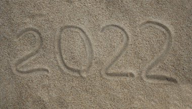 2022 'de kumsalda yazılmış, yeni yıl seyahati tebrik kartı.