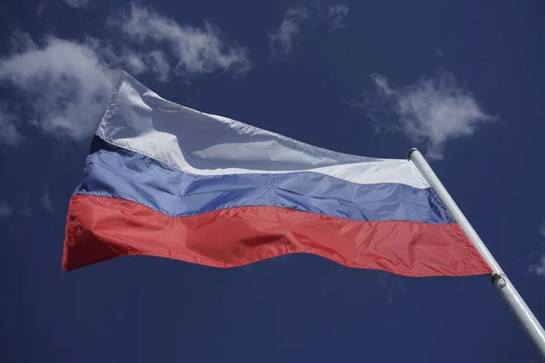ロシアの三色の旗が青い空に向かって風に振っている 青空の上のロシア国旗背景 — ストック写真