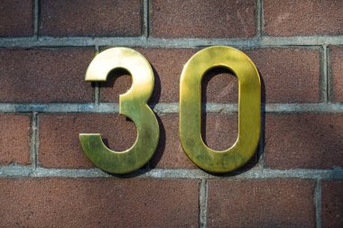 30 numaralı ev (30) kırmızı tuğlalı arka planda altın metal basamaklar halinde.. 