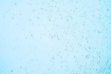 Su damlacıkları cam yüzey mavisi üzerinden perspektif sağlar. Yağmur damlası dokusundan mavi su