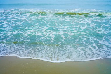 Rüya gibi bir plaj. Önünde dalgaların ve kumların olduğu deniz manzaralı bir deniz manzarası. Okyanus sahili tatili