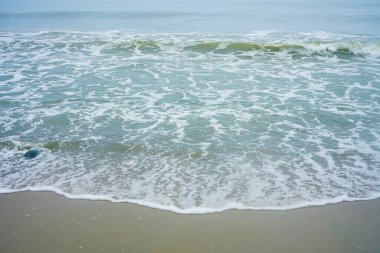 Rüya gibi bir plaj. Önünde dalgaların ve kumların olduğu deniz manzaralı bir deniz manzarası. Okyanus sahili tatili