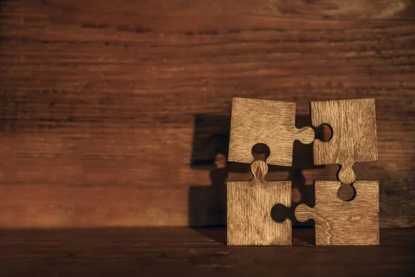 Vier Braune Puzzleteile Auf Einem Holztisch Leerer Kopierraum Für Inschriften — Stockfoto