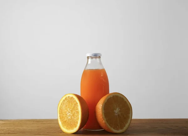 ボトルのオレンジフルーツとオレンジジュース白ガラスと白の背景に隔離された氷 — ストック写真