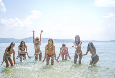 Su sıçratan bir grup mutlu genç kadın. 
