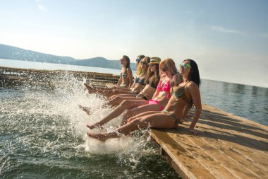 Güzel yaz günbatımında su sıçratan bir grup mutlu genç kadın..
