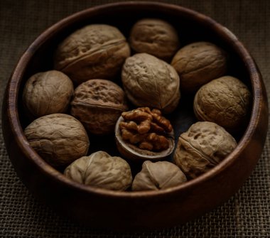 Tahta bir kasede ceviz ve fındık. Görüntüyü yaklaştır. Arka planda çuval bezi. 