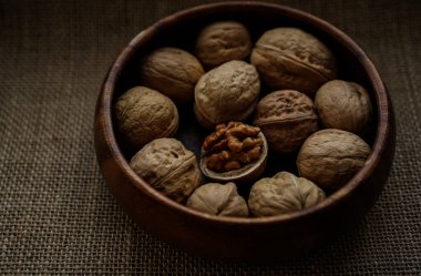 Tahta bir kasede ceviz ve fındık. Görüntüyü yaklaştır. Arka planda çuval bezi. 