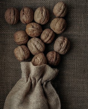 Kalıplı bir arka planda, çuval bezin içinde ceviz. Çuval içinde fındık.. 