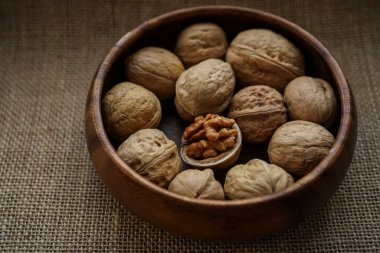 Tahta bir kasede ceviz ve fındık. Görüntüyü yaklaştır. Arka planda çuval bezi. 