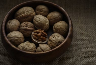 Tahta bir kasede ceviz ve fındık. Görüntüyü yaklaştır. Arka planda çuval bezi. 