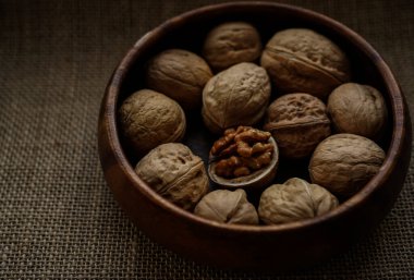 Tahta bir kasede ceviz ve fındık. Görüntüyü yaklaştır. Arka planda çuval bezi. 