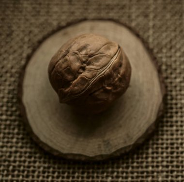 Kahverengi bir çuval bezi üzerinde yuvarlak ceviz. Çuval bezinde kabuklu ceviz.