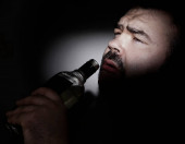 vousatý Muž s kocovinou pití Jim nebo vodka - alkoholický nápoj z průhledné skleněné láhve