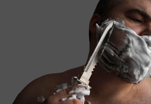 Βάναυσος Άνθρωπος Ξυρίζεται Ένα Μεγάλο Επικίνδυνο Σκαλισμένο Μαχαίρι Απομονωμένο Γκρι — Φωτογραφία Αρχείου