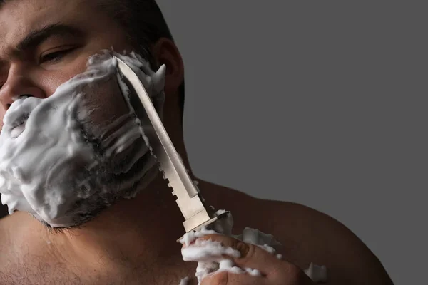 Βάναυσος Άνθρωπος Ξυρίζεται Ένα Μεγάλο Επικίνδυνο Σκαλισμένο Μαχαίρι Απομονωμένο Γκρι — Φωτογραφία Αρχείου