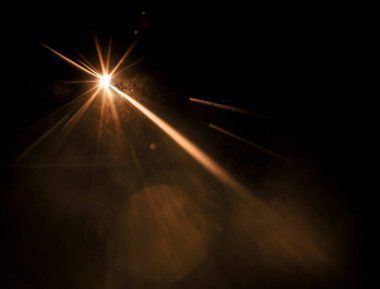 Parlak güneş, güneş ışığı, güneş ışığı tasarımı. Sarı sıcak ışık efekti, güneş ışınları, siyah arkaplanda izole edilmiş altın ışınlar. yıldız tozu