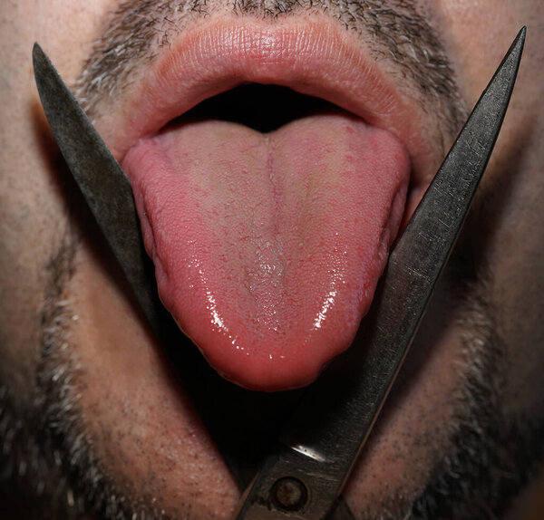 bearded man with mustache cutting his tongue with iron scissors. close up image.