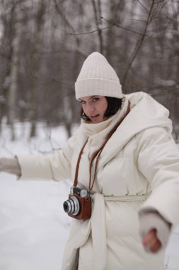 Ormanda kış yürüyüşüne çıkmış kameralı bir kız.