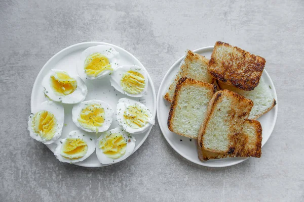 Halves of a boiled eggs on a plate with space for text and fried toast — Stock Photo, Image