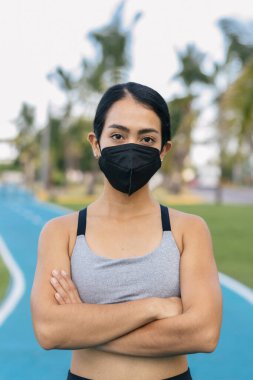 Yüz maskesi takan ve spor kıyafeti giyen genç İspanyol kadın.