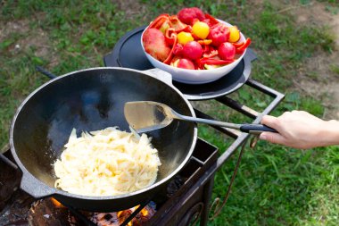 Kazanda ızgarada sebze pişirmek. Soğanları kazanda kızart..