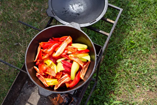 Здорова овочева їжа. Приготувати червоний, жовтий болгарський перець у котлі. Їжа, приготована на вогні, на відкритому повітрі . — стокове фото