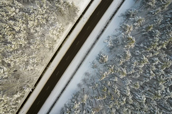 Strada nera e alberi con neve fredda in montagna — Foto Stock