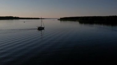 Mavi denizde yüksek hızda seyreden lüks sürat teknesinin fotokopi uzayına sahip bir hava aracı. Yelkenli yatın ve suda altın gün batımının yansıması. Okyanustaki denizcilik gemisinde boş zaman. 