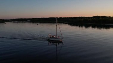 Mavi denizde yüksek hızda seyreden lüks sürat teknesinin fotokopi uzayına sahip bir hava aracı. Yelkenli yatın ve suda altın gün batımının yansıması. Okyanustaki denizcilik gemisinde boş zaman. 