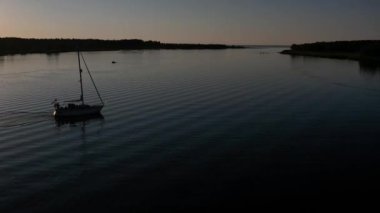 Mavi denizde yüksek hızda seyreden lüks sürat teknesinin fotokopi uzayına sahip bir hava aracı. Yelkenli yatın ve suda altın gün batımının yansıması. Okyanustaki denizcilik gemisinde boş zaman. 