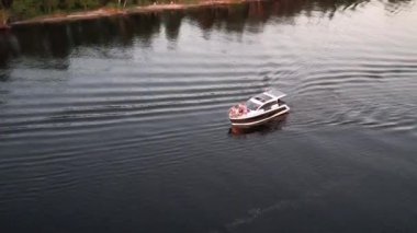 Mavi denizde yüksek hızda seyreden lüks sürat teknesinin fotokopi uzayına sahip bir hava aracı. Yelkenli yatın ve suda altın gün batımının yansıması. Okyanustaki denizcilik gemisinde boş zaman. 